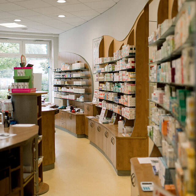 Pharmazeutische Produkte in einem hellen, modernen Verkaufsraum mit Regalen.